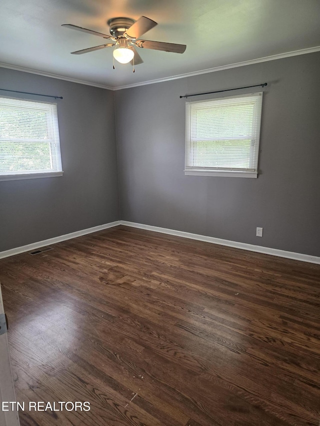 empty room featuring visible vents, baseboards, a ceiling fan, crown molding, and dark wood-type flooring