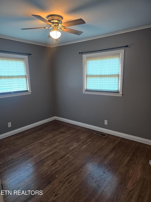 empty room with ceiling fan, a healthy amount of sunlight, wood finished floors, and visible vents