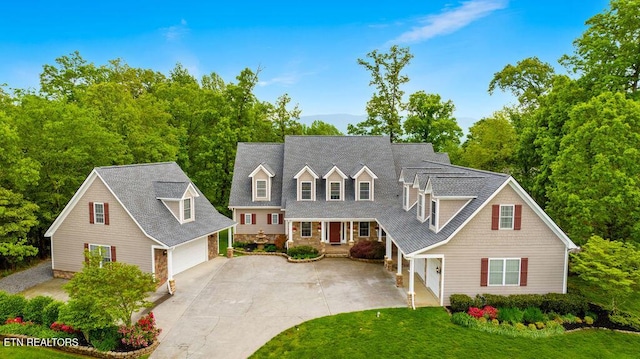 view of front of house with a garage, a front lawn, driveway, and stone siding
