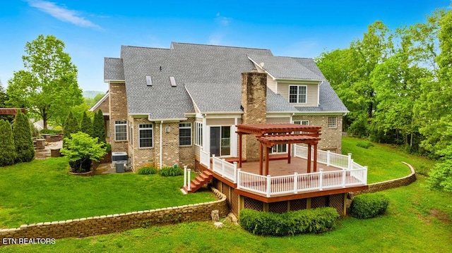 rear view of property featuring a lawn, a pergola, brick siding, and a wooden deck