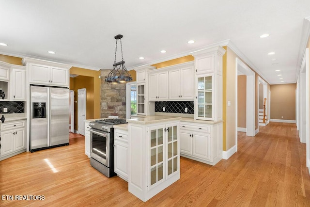 kitchen with white cabinetry, stainless steel appliances, backsplash, and light countertops
