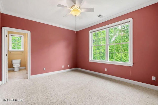 carpeted spare room featuring visible vents, a healthy amount of sunlight, and crown molding