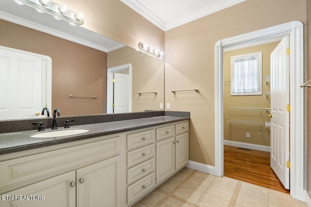 bathroom featuring tile patterned floors, vanity, baseboards, visible vents, and crown molding