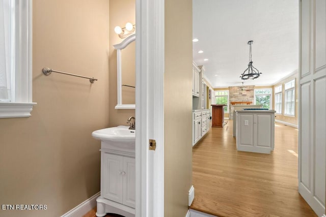 bathroom with wood finished floors, vanity, recessed lighting, and baseboards