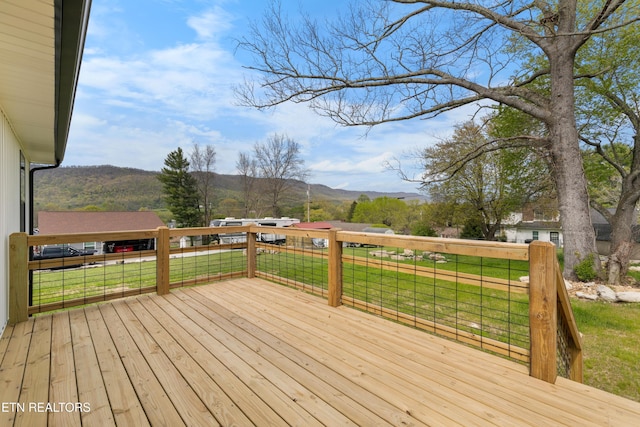 wooden terrace featuring a yard and a mountain view