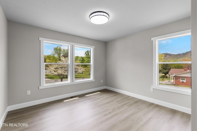 spare room with wood finished floors and baseboards