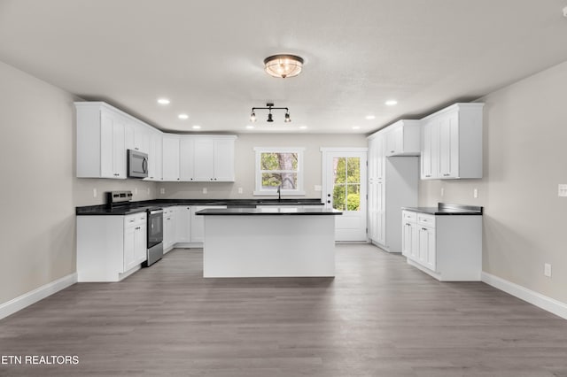 kitchen featuring recessed lighting, dark countertops, appliances with stainless steel finishes, and baseboards