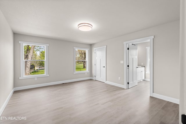 interior space featuring baseboards and light wood-style floors