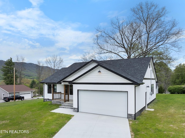 ranch-style house featuring a mountain view, concrete driveway, an attached garage, a shingled roof, and a front yard
