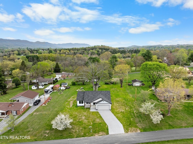 birds eye view of property with a wooded view and a mountain view