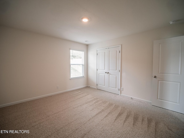 unfurnished bedroom with baseboards, a closet, and carpet