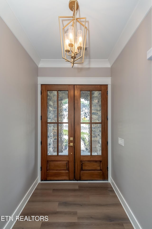 entryway featuring crown molding, wood finished floors, an inviting chandelier, french doors, and baseboards