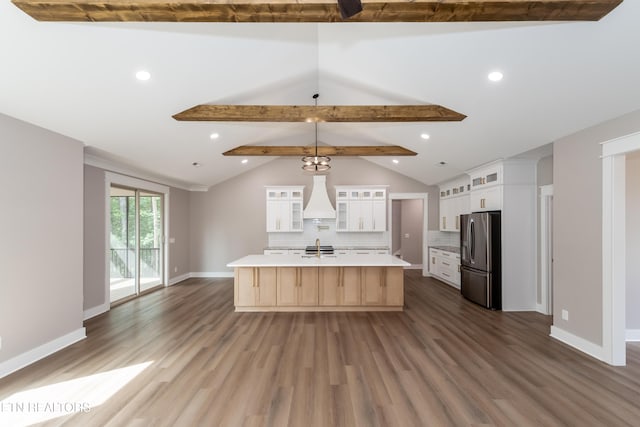 kitchen with light countertops, vaulted ceiling with beams, freestanding refrigerator, decorative backsplash, and custom exhaust hood
