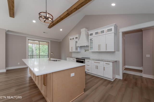 kitchen featuring premium range hood, light countertops, dark wood-style floors, and a sink