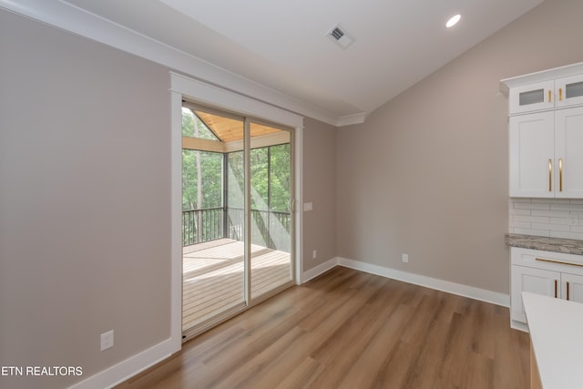 unfurnished dining area featuring light wood-type flooring, baseboards, visible vents, recessed lighting, and lofted ceiling