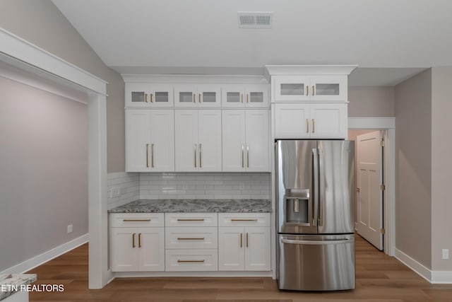 kitchen featuring backsplash, visible vents, baseboards, and stainless steel fridge with ice dispenser