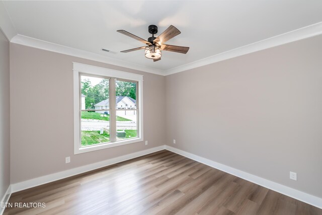 unfurnished room with a ceiling fan, wood finished floors, baseboards, ornamental molding, and visible vents