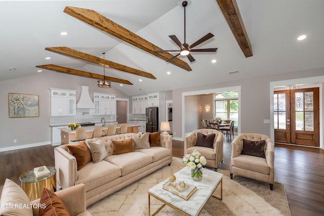 living area featuring wood finished floors, a ceiling fan, visible vents, and beam ceiling