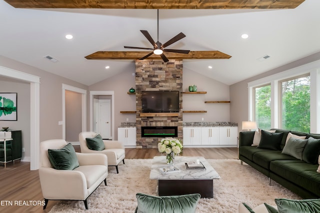 living area with lofted ceiling with beams, a ceiling fan, visible vents, and light wood-style flooring