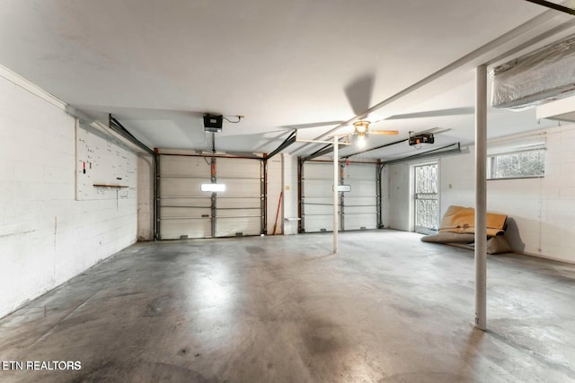 garage featuring concrete block wall and a garage door opener