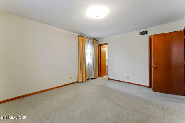 carpeted empty room with baseboards and visible vents
