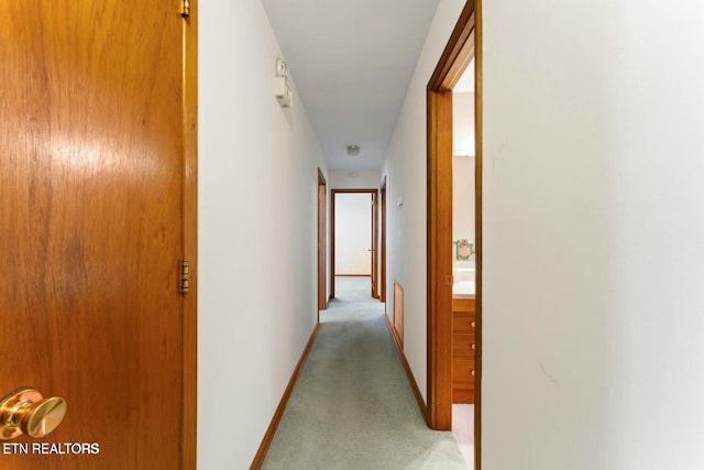 corridor with light carpet and baseboards