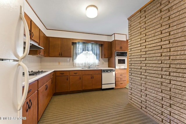 kitchen with under cabinet range hood, light countertops, light carpet, a sink, and white appliances