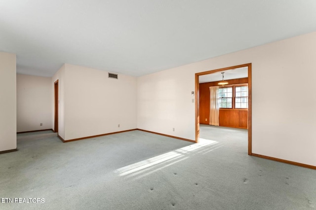 carpeted empty room featuring baseboards and visible vents