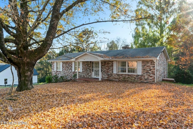 single story home with brick siding and a chimney