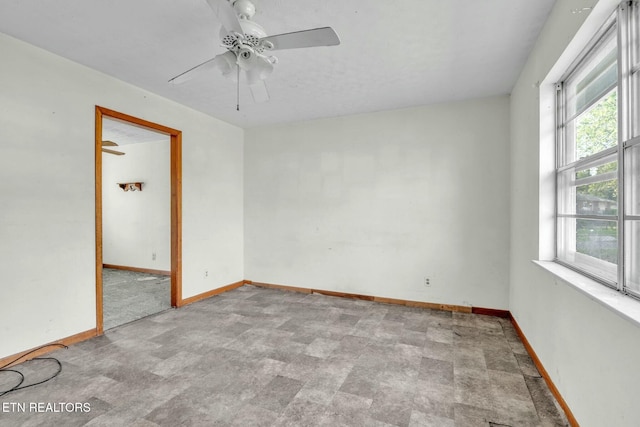 empty room featuring baseboards and ceiling fan