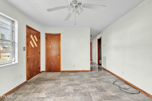 interior space with a ceiling fan and baseboards