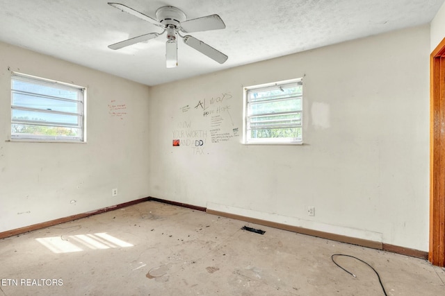 unfurnished room featuring ceiling fan and baseboards