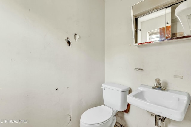 half bathroom with toilet and a sink