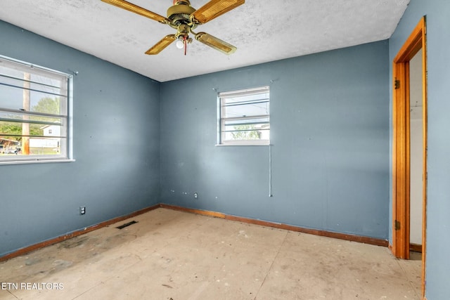 unfurnished room with baseboards, a ceiling fan, a textured ceiling, and visible vents
