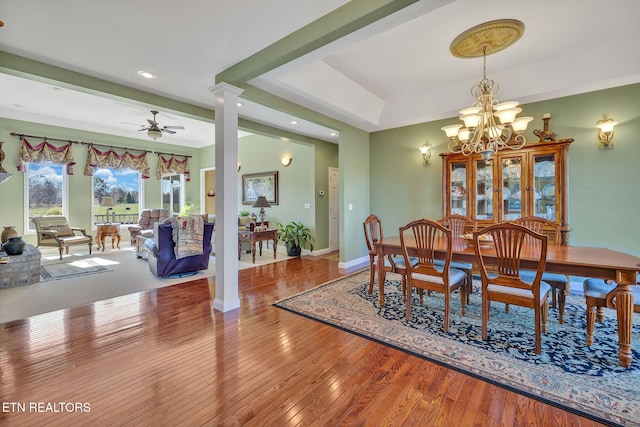 135 Austin Ln, Deer Lodge, TN 37726 - dining space featuring ceiling fan with notable chandelier, hardwood / wood-style flooring, a raised ceiling, baseboards, and ornate columns