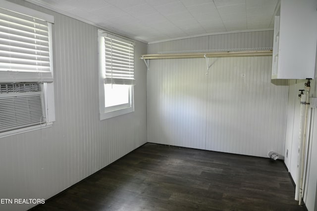 laundry area featuring dark wood-type flooring and crown molding