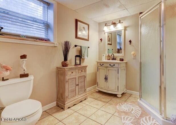 full bath featuring toilet, vanity, tile patterned flooring, and a stall shower