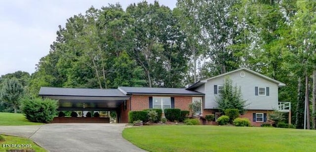 split level home with a carport, aphalt driveway, a front yard, and brick siding