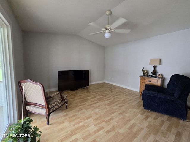 living area featuring lofted ceiling, a ceiling fan, wood finished floors, and baseboards