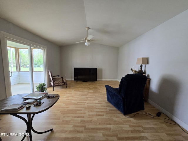 living area with baseboards, lofted ceiling, light wood-style flooring, and ceiling fan