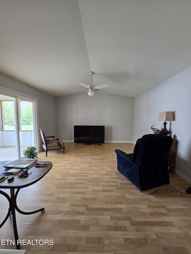 living area featuring lofted ceiling, a ceiling fan, wood finished floors, and baseboards