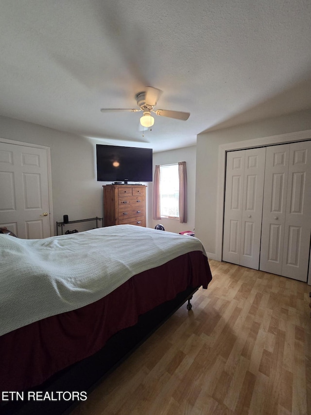 bedroom featuring a ceiling fan, light wood finished floors, and a closet