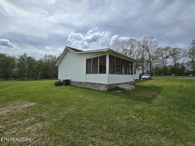 view of side of property with a lawn, central AC, a sunroom, and crawl space