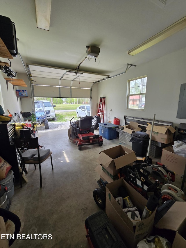 garage with a porch, a garage door opener, and electric panel