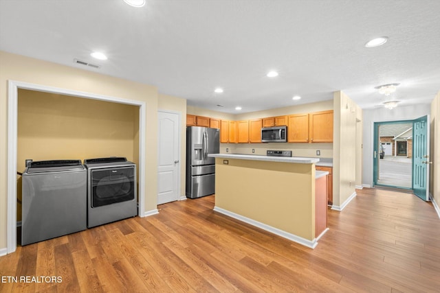 7143 La Christa Way, Knoxville, TN 37921 - kitchen with light wood finished floors, visible vents, independent washer and dryer, light countertops, and appliances with stainless steel finishes