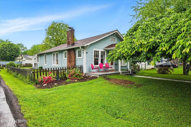 single story home with fence, a chimney, and a front yard