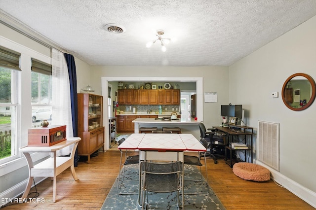 dining room featuring visible vents, wood finished floors, and plenty of natural light