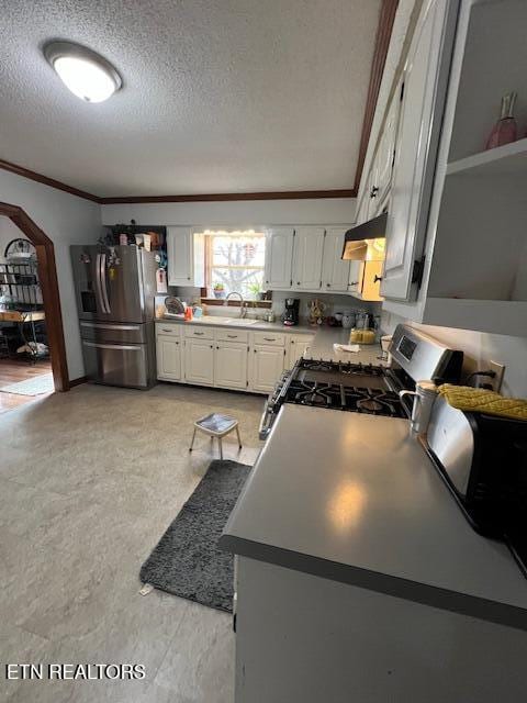 205 Hickory Ln, Jacksboro, TN 37757 - kitchen featuring stainless steel appliances, ornamental molding, a textured ceiling, under cabinet range hood, and white cabinets