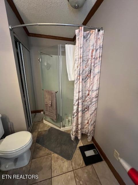 205 Hickory Ln, Jacksboro, TN 37757 - full bathroom featuring toilet, tile patterned floors, a textured ceiling, baseboards, and a shower stall