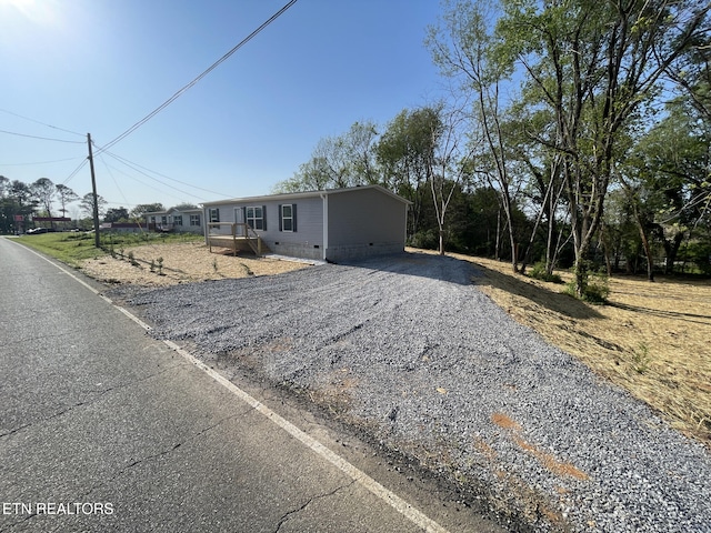 manufactured / mobile home with gravel driveway and crawl space